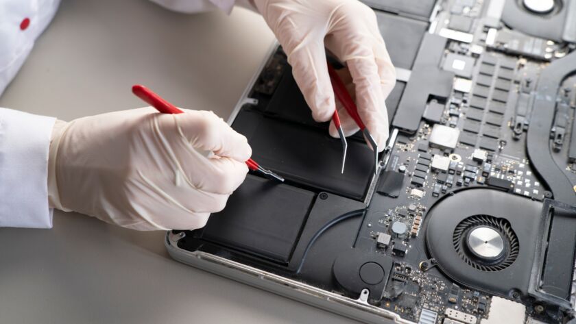 a laptop battery fix, serviceman changing the battery components